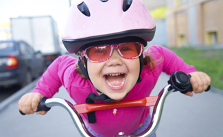 Kid riding a bike with helmet and sunglasses